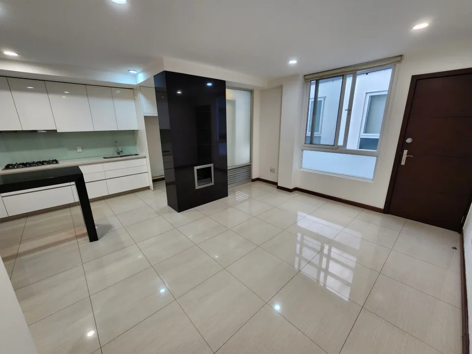 Interior de departamento con cocina abierta y espacio para sala y comedor